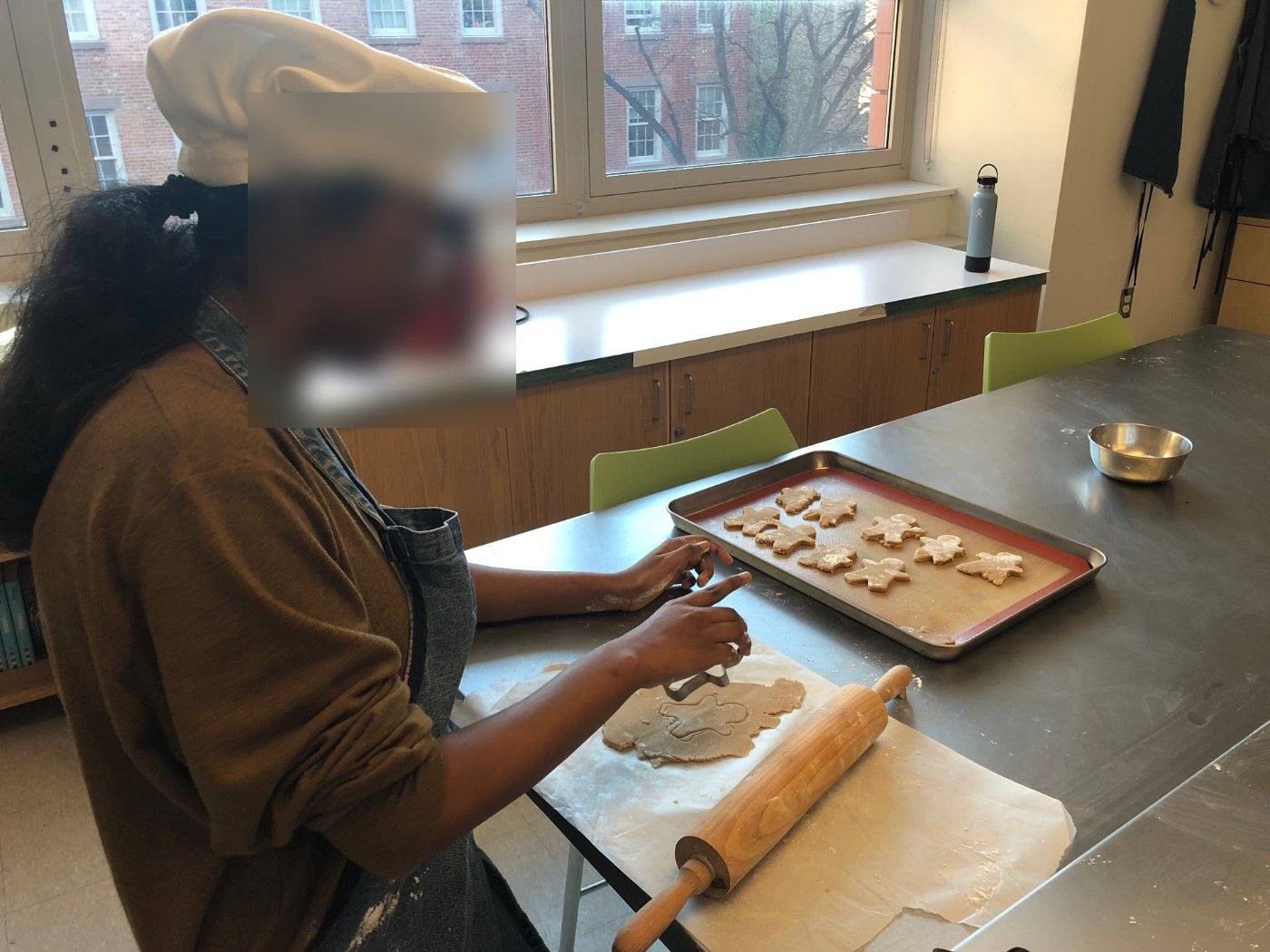 Student cutting gingerbread cookies with a cookie cutter
