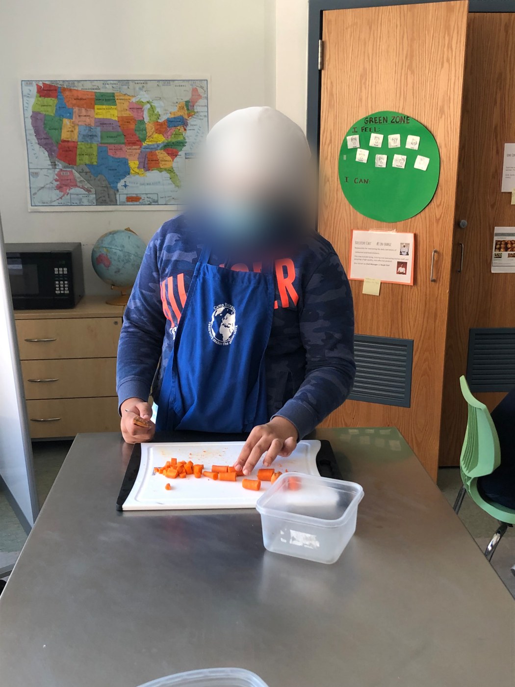 Student dicing carrots at a prep station during a cooking lesson