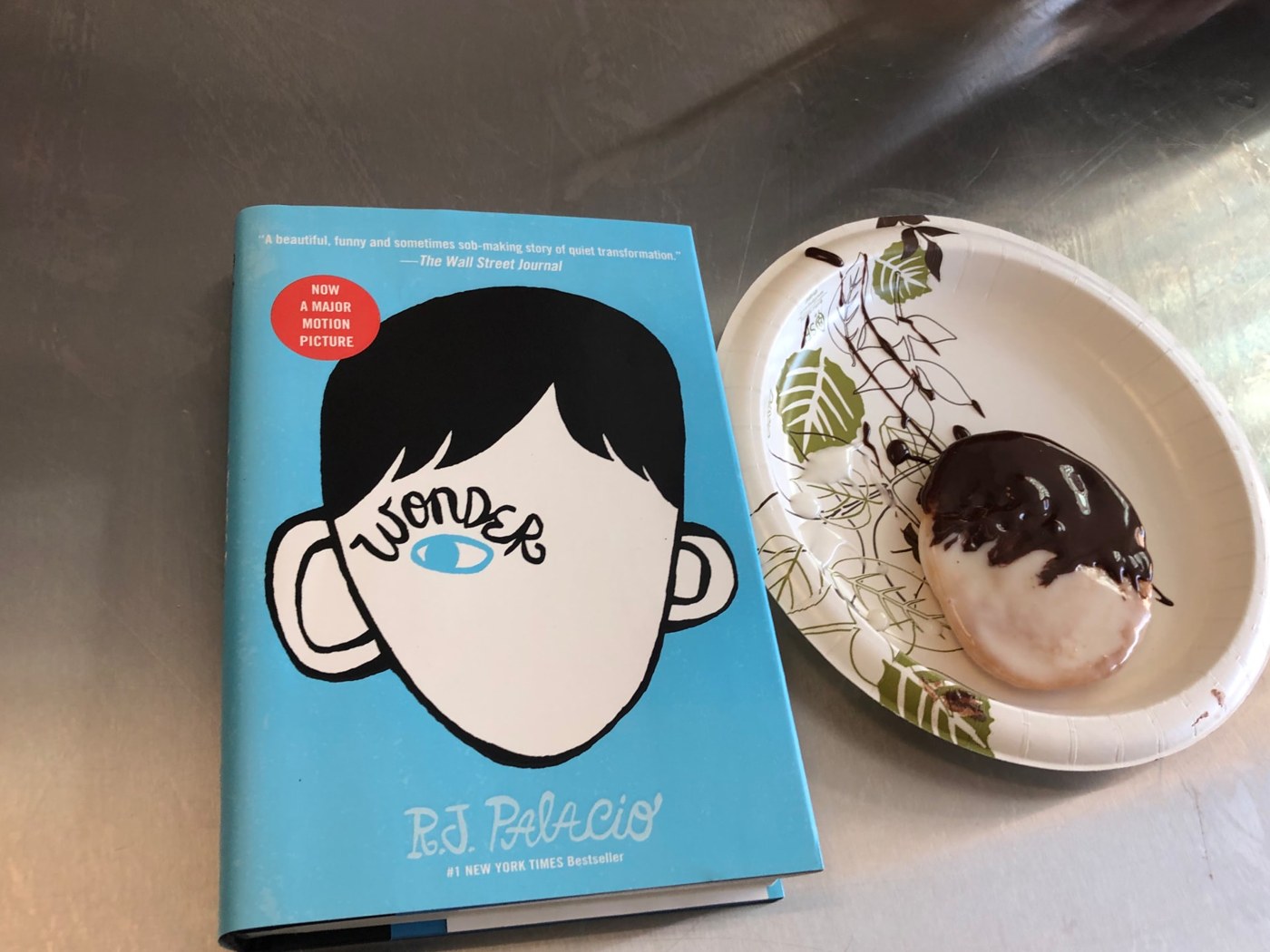 A book and a chocolate-glazed doughnut made during a lesson